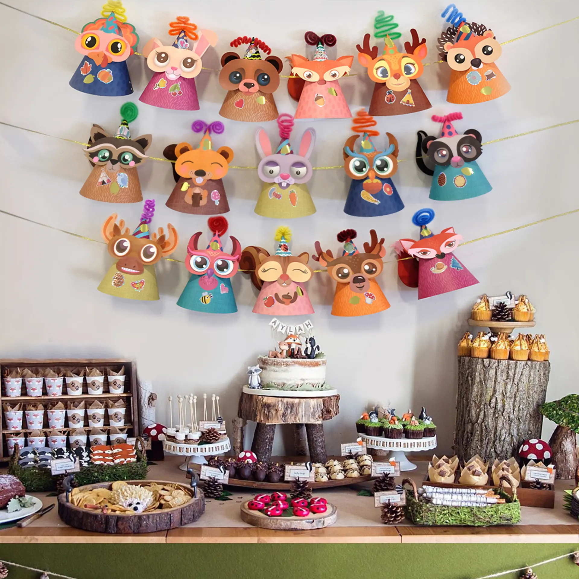 Woodland animal party hats made from a Glittery Garden kit strung above a forest-themed birthday dessert table